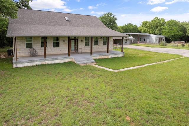 back of property featuring a shingled roof, a porch, driveway, and a yard