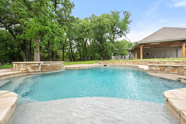 pool featuring an in ground hot tub and fence