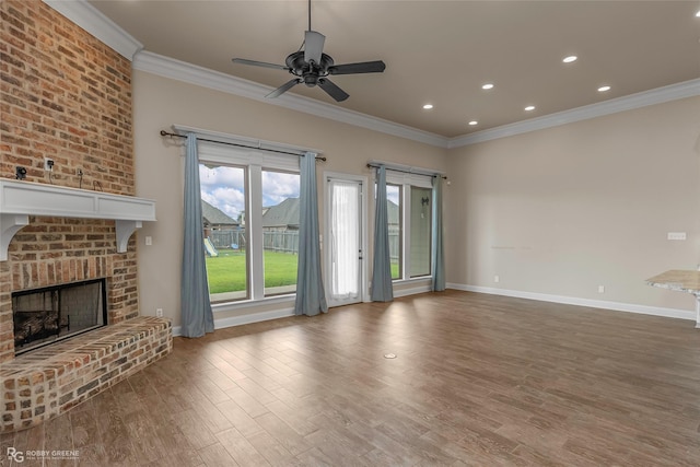 unfurnished living room with wood finished floors, a fireplace, baseboards, and ornamental molding