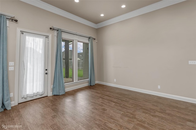 empty room featuring crown molding, recessed lighting, baseboards, and wood finished floors