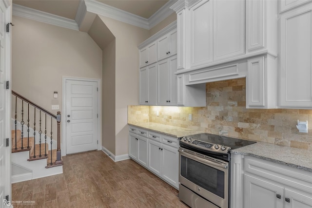 kitchen with backsplash, light wood-style flooring, crown molding, and electric range