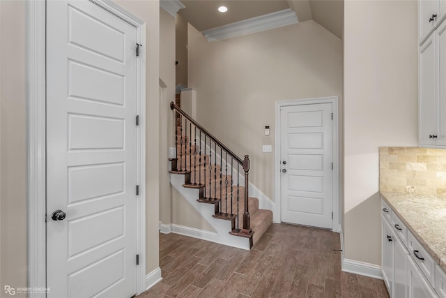 interior space featuring dark wood-type flooring, baseboards, stairway, ornamental molding, and recessed lighting