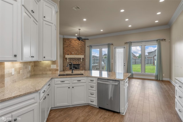 kitchen featuring dishwasher, ornamental molding, visible vents, a sink, and a peninsula