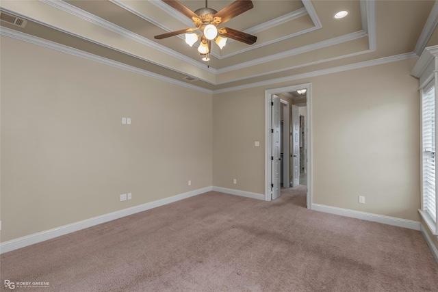 empty room with a tray ceiling, visible vents, ceiling fan, light colored carpet, and ornamental molding