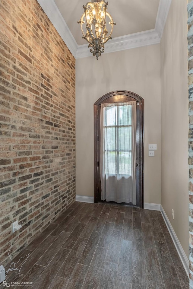 entryway featuring an inviting chandelier, dark wood finished floors, baseboards, and crown molding