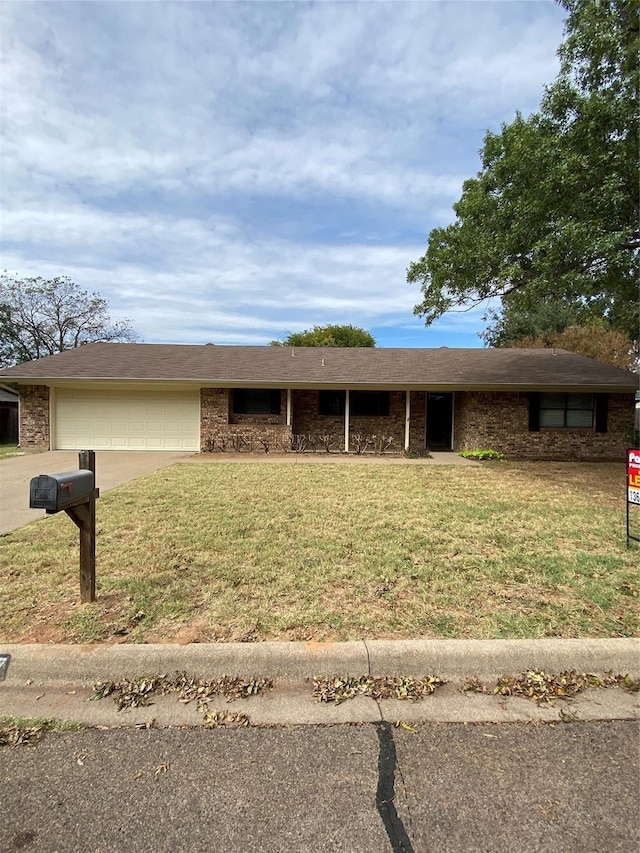ranch-style house with a front lawn, driveway, brick siding, and an attached garage