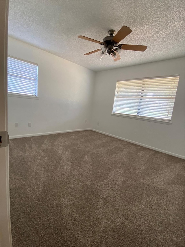 carpeted spare room featuring a textured ceiling, baseboards, and a ceiling fan