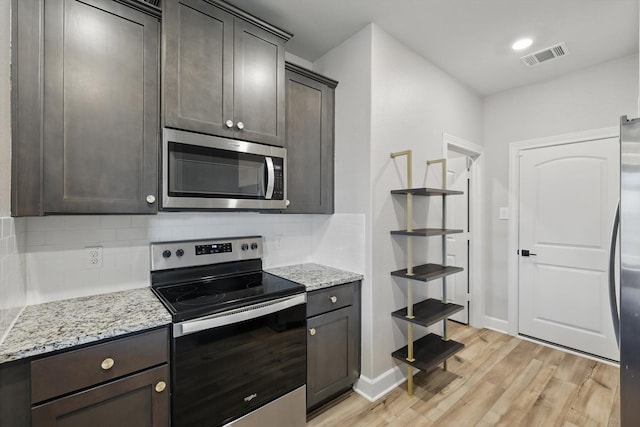 7616 Duck Bay Rd, Fort Worth, TX 76120 - kitchen featuring stainless steel appliances, light wood-style flooring, tasteful backsplash, and dark brown cabinetry