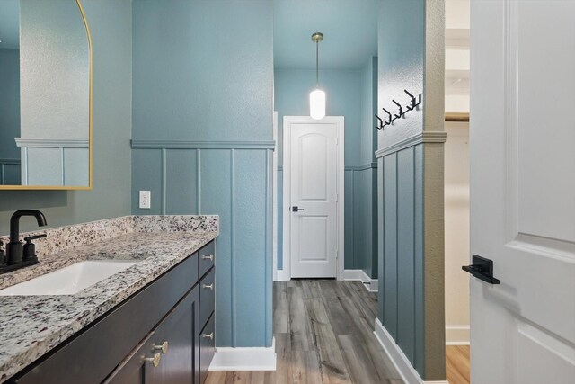 7616 Duck Bay Rd, Fort Worth, TX 76120 - bathroom with wood finished floors, a wainscoted wall, a decorative wall, and vanity
