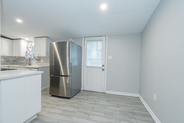 309 James St, Terrell, TX 75160 - kitchen with freestanding refrigerator, light countertops, tasteful backsplash, white cabinets, and recessed lighting