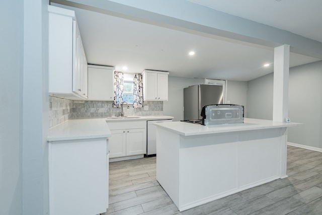 309 James St, Terrell, TX 75160 - kitchen featuring a sink, dishwasher, refrigerator, decorative backsplash, and white cabinets