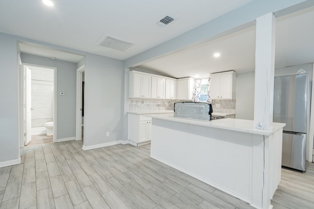 309 James St, Terrell, TX 75160 - kitchen featuring freestanding refrigerator, decorative backsplash, light countertops, white cabinetry, and recessed lighting