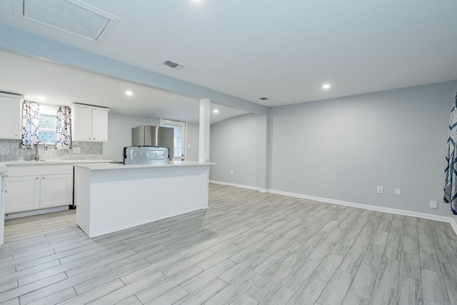 309 James St, Terrell, TX 75160 - kitchen with a sink, light countertops, tasteful backsplash, white cabinets, and open floor plan