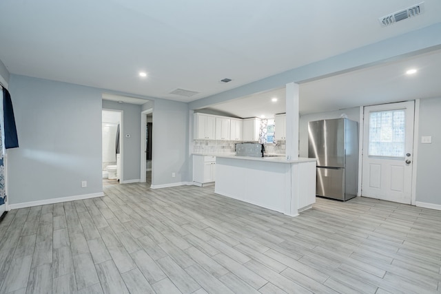 309 James St, Terrell, TX 75160 - kitchen featuring freestanding refrigerator, light countertops, white cabinets, backsplash, and recessed lighting
