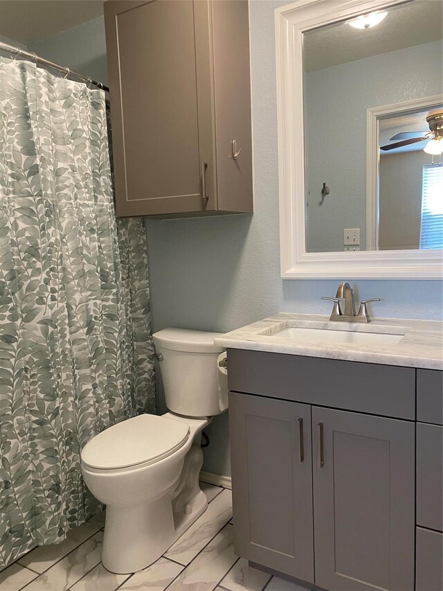 4404 Bobbie Ann Dr, Granbury, TX 76049 - bathroom featuring marble look tiles, vanity, toilet, and ceiling fan
