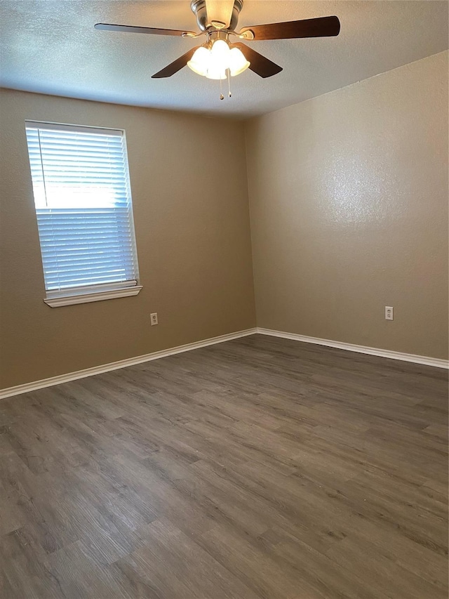 empty room with wood finished floors, baseboards, and ceiling fan
