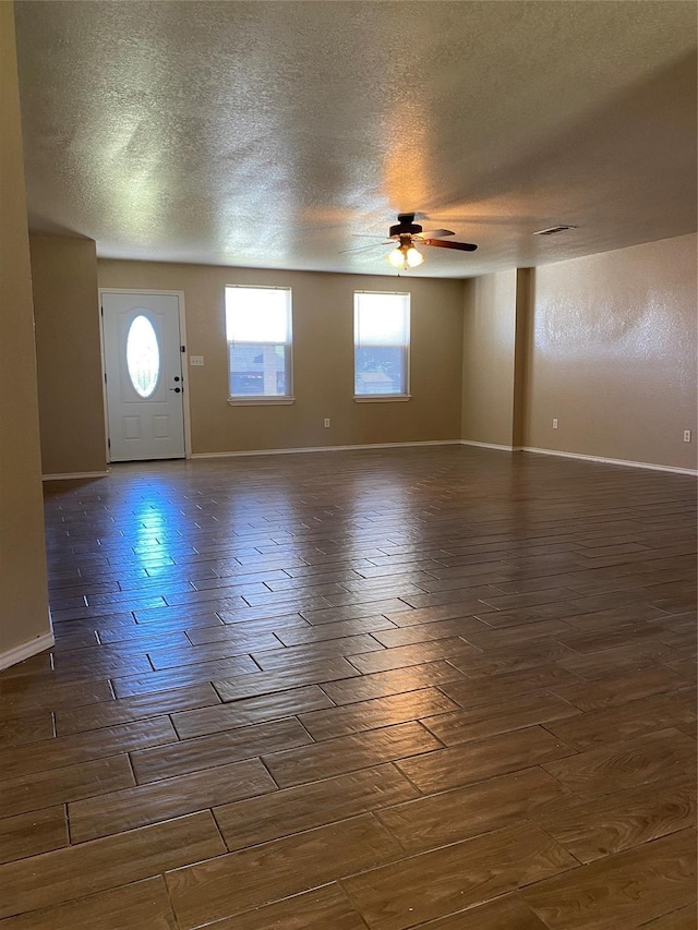4404 Bobbie Ann Dr, Granbury, TX 76049 - foyer featuring a ceiling fan, a textured ceiling, parquet flooring, and baseboards