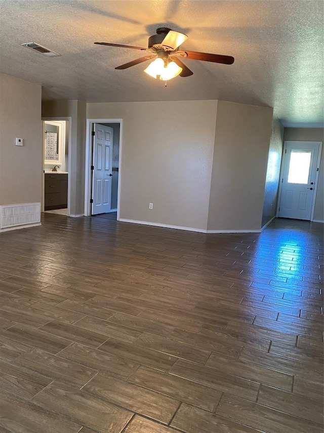 4404 Bobbie Ann Dr, Granbury, TX 76049 - unfurnished living room with a textured ceiling, dark wood-style flooring, ceiling fan, baseboards, and a sink
