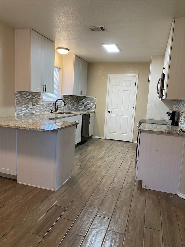 4404 Bobbie Ann Dr, Granbury, TX 76049 - kitchen with dark wood-type flooring, a sink, black dishwasher, light stone countertops, and a peninsula