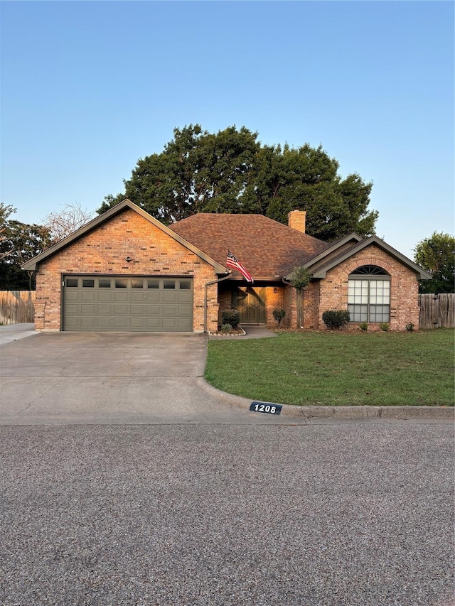 single story home with a garage, a chimney, a front yard, brick siding, and driveway