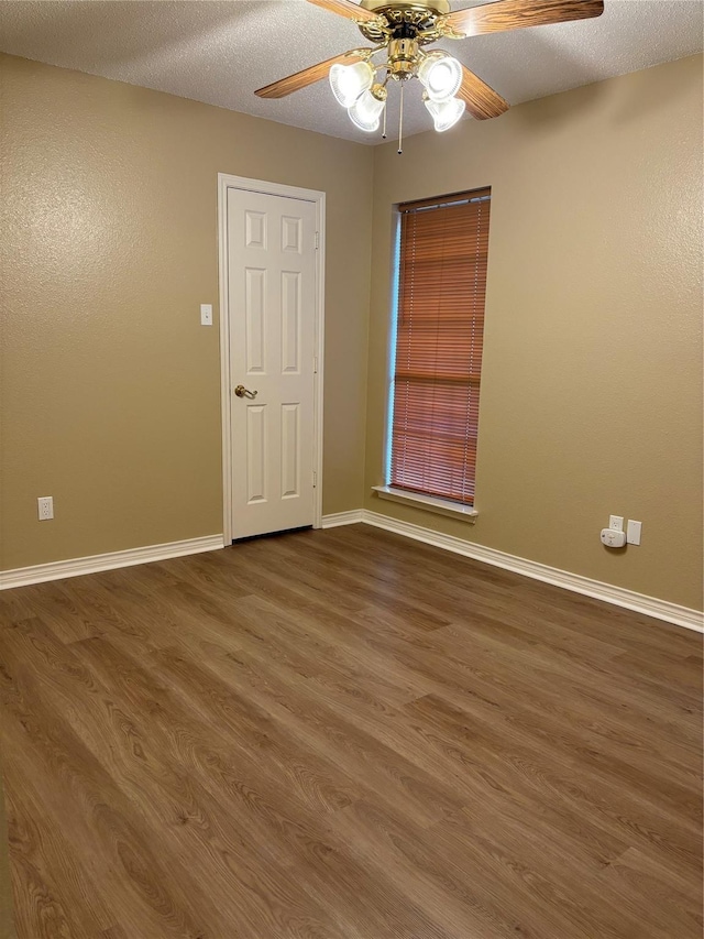 unfurnished room with baseboards, ceiling fan, and wood finished floors