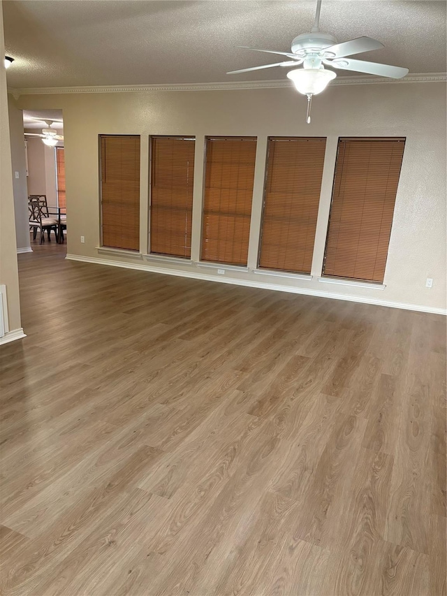 interior space with a ceiling fan, light wood finished floors, and a textured ceiling