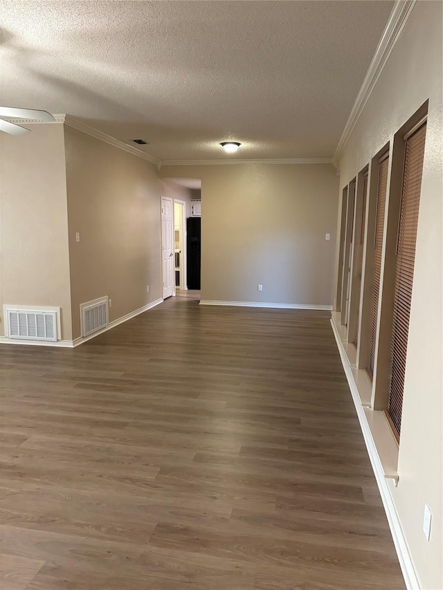 empty room featuring ornamental molding, a textured ceiling, and visible vents