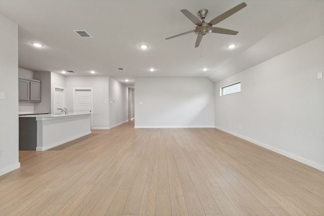 unfurnished living room featuring ceiling fan, baseboards, light wood finished floors, and visible vents