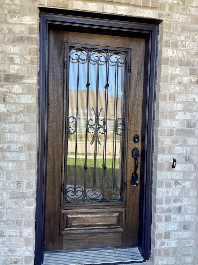 property entrance with a gate and brick siding