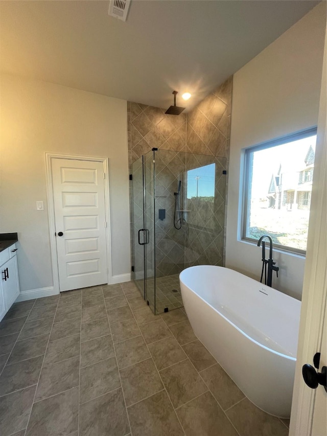 full bath featuring a stall shower, a freestanding bath, visible vents, tile patterned flooring, and vanity