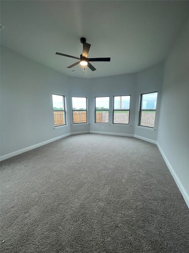 spare room with baseboards, a ceiling fan, a healthy amount of sunlight, and carpet floors