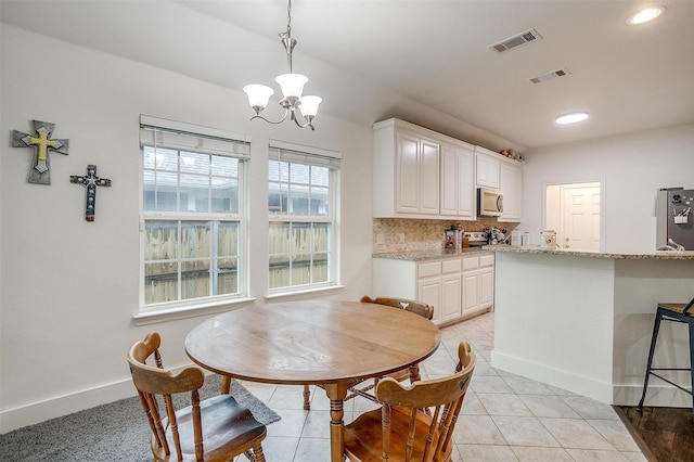 dining area featuring visible vents, baseboards, light tile patterned flooring, and a notable chandelier