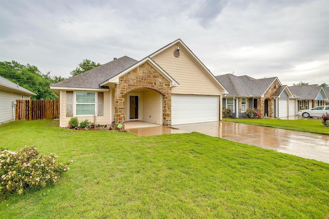 single story home featuring fence, an attached garage, stone siding, driveway, and a front lawn