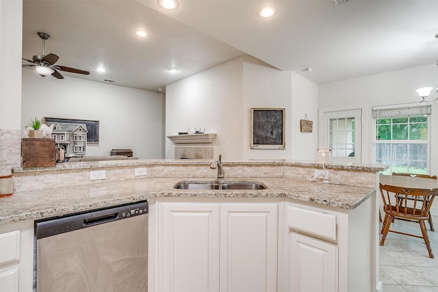 kitchen featuring recessed lighting, dishwasher, light stone counters, and a sink