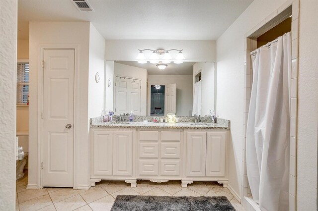 full bath featuring double vanity, tile patterned floors, visible vents, and a sink