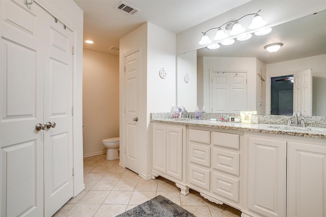 bathroom with toilet, visible vents, a sink, tile patterned flooring, and double vanity