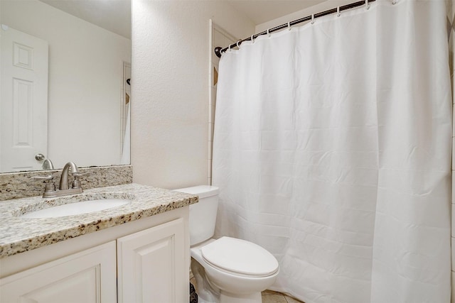 full bath with curtained shower, vanity, and toilet