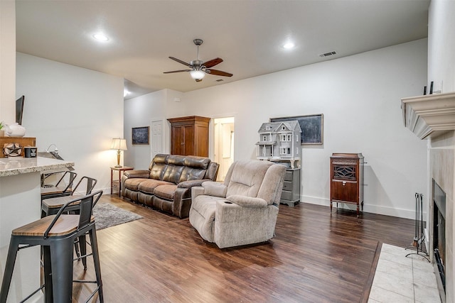 living area featuring wood finished floors, a fireplace with flush hearth, visible vents, ceiling fan, and recessed lighting