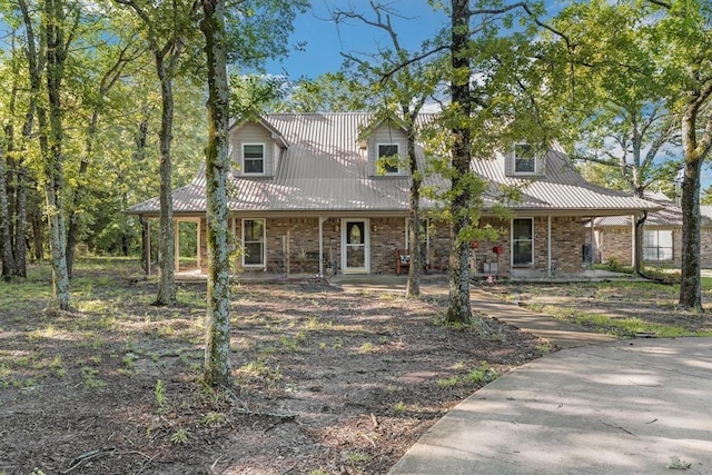 906 County Road 2770, Honey Grove, TX 75446 - new england style home featuring covered porch, metal roof, and brick siding