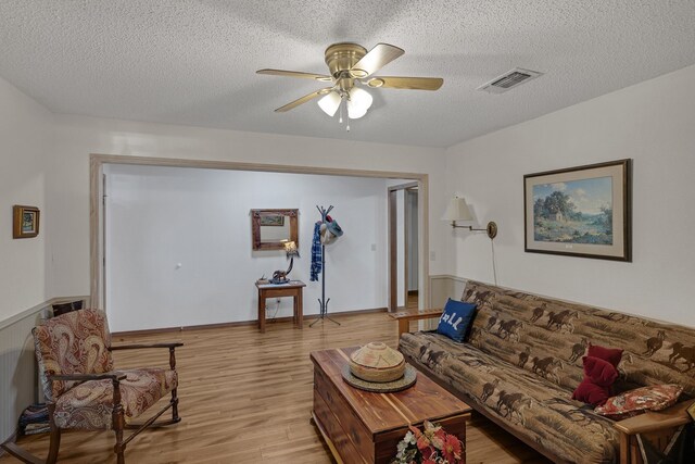 906 County Road 2770, Honey Grove, TX 75446 - living area featuring light wood finished floors, a textured ceiling, ceiling fan, and visible vents