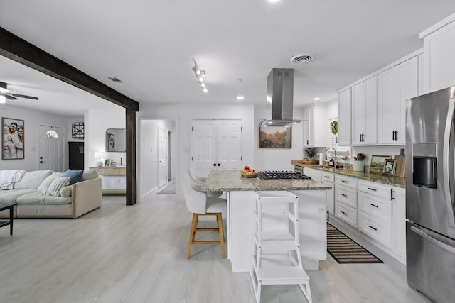 1718 Heather Rd, Gainesville, TX 76240 - kitchen with stainless steel fridge with ice dispenser, island range hood, a sink, stovetop, and a center island