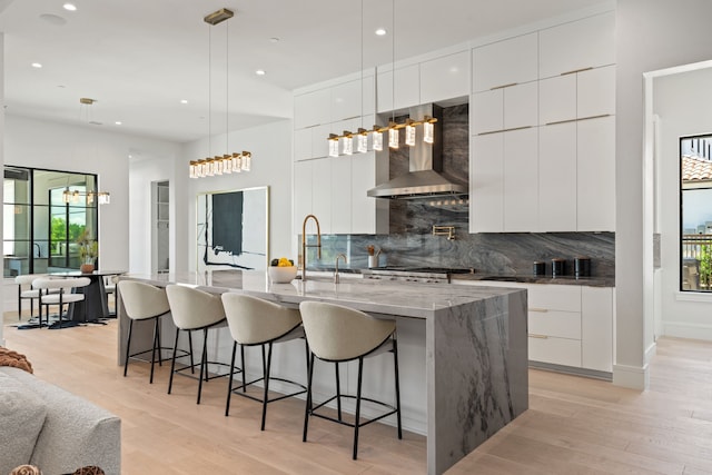 3650 Balfour Ct, Frisco, TX 75034 - kitchen with modern cabinets, wall chimney range hood, light wood-type flooring, and recessed lighting