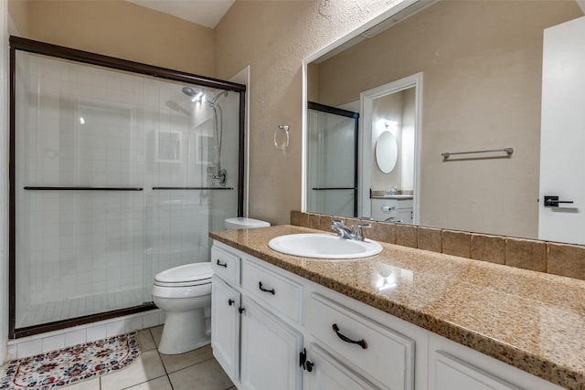 bathroom featuring a stall shower, vanity, toilet, and tile patterned floors