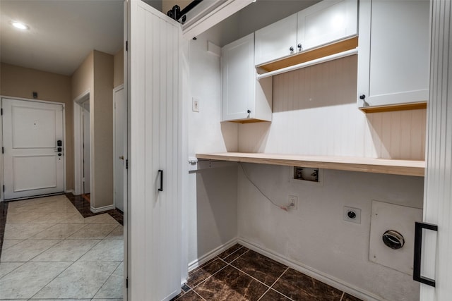 clothes washing area featuring cabinet space, baseboards, hookup for an electric dryer, and hookup for a washing machine