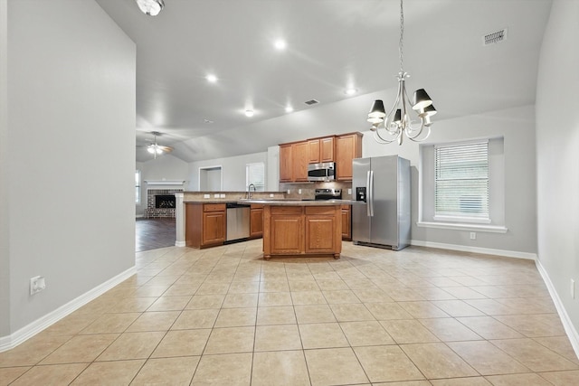 kitchen featuring lofted ceiling, visible vents, open floor plan, light tile patterned floors, and appliances with stainless steel finishes