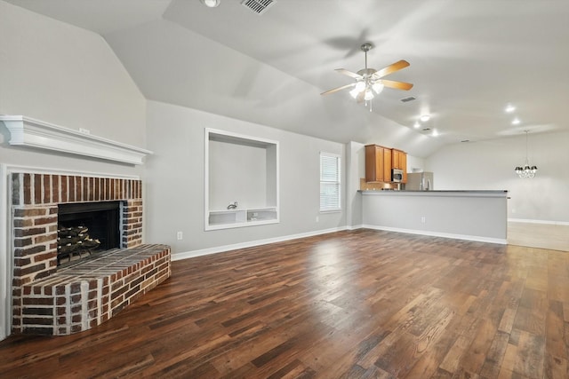 unfurnished living room featuring a ceiling fan, a fireplace, wood finished floors, and vaulted ceiling