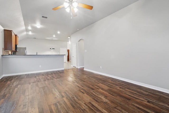 unfurnished living room with lofted ceiling, visible vents, dark wood finished floors, ceiling fan, and baseboards