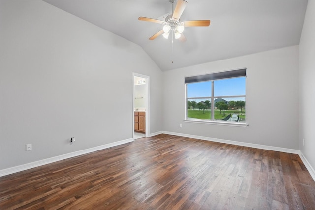 spare room with vaulted ceiling, dark wood-style flooring, baseboards, and ceiling fan