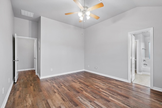 unfurnished bedroom with connected bathroom, wood finished floors, visible vents, baseboards, and vaulted ceiling