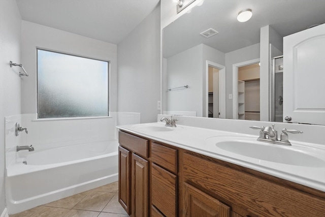 bathroom featuring tile patterned floors, a bath, visible vents, and a sink